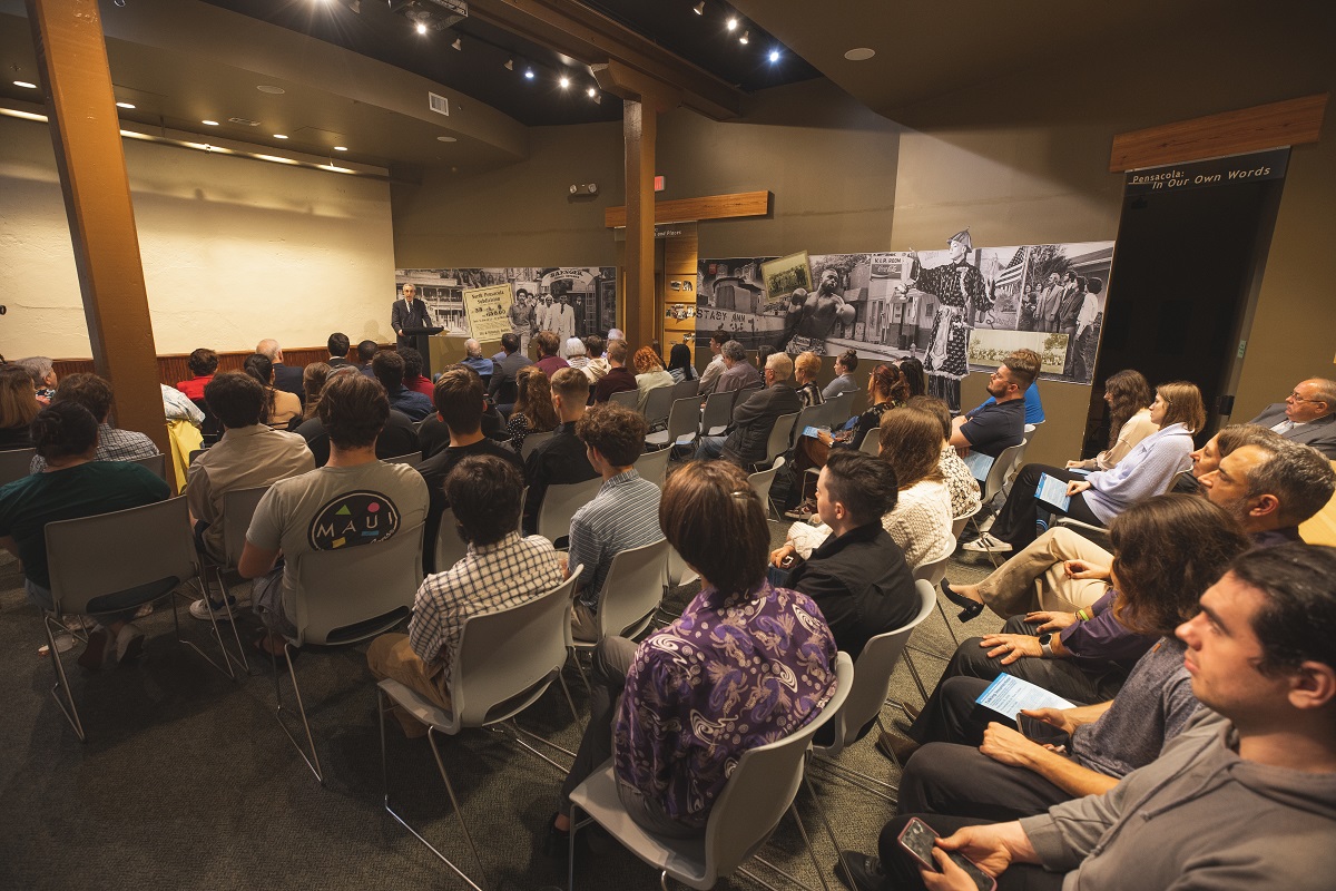 People at a lecture in the theatre room at Voices of Pensacola